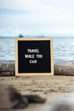 a sign that says travel while you can
