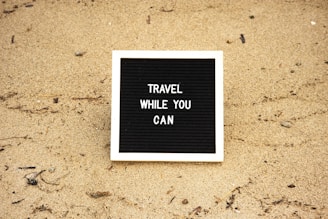 a black and white sign that says travel while you can