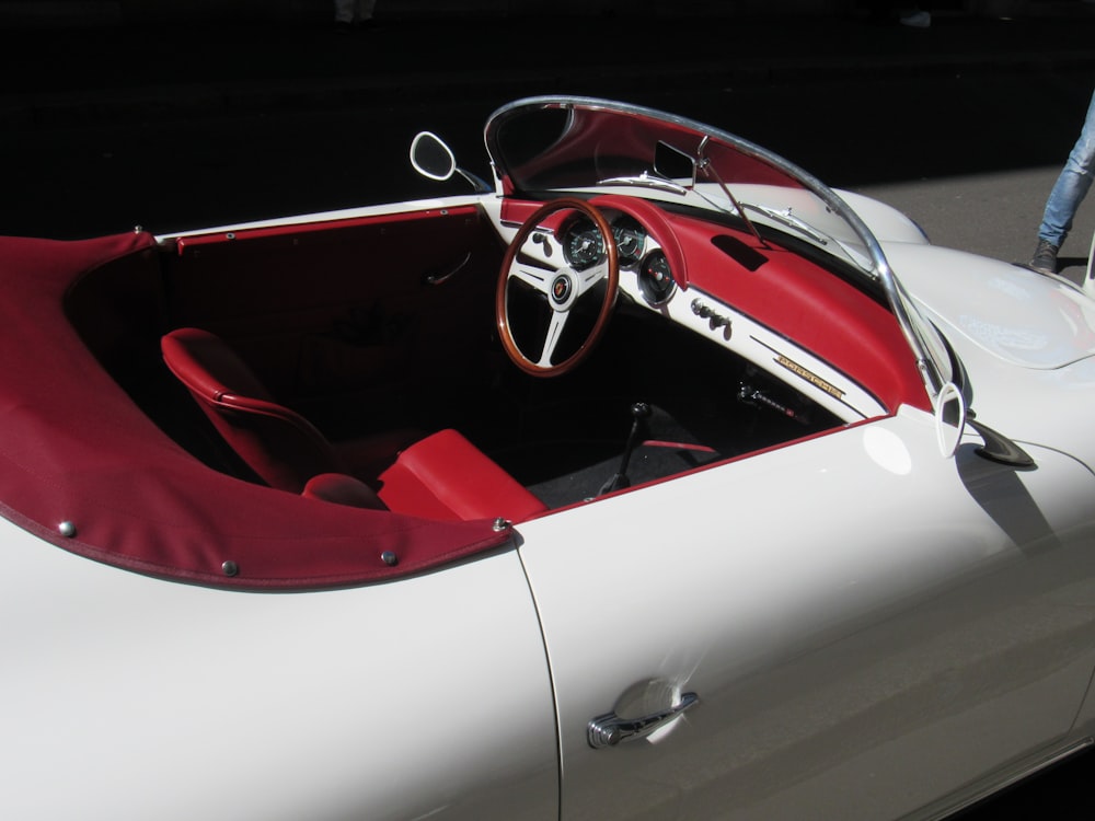 a white car with a red seat and a steering wheel