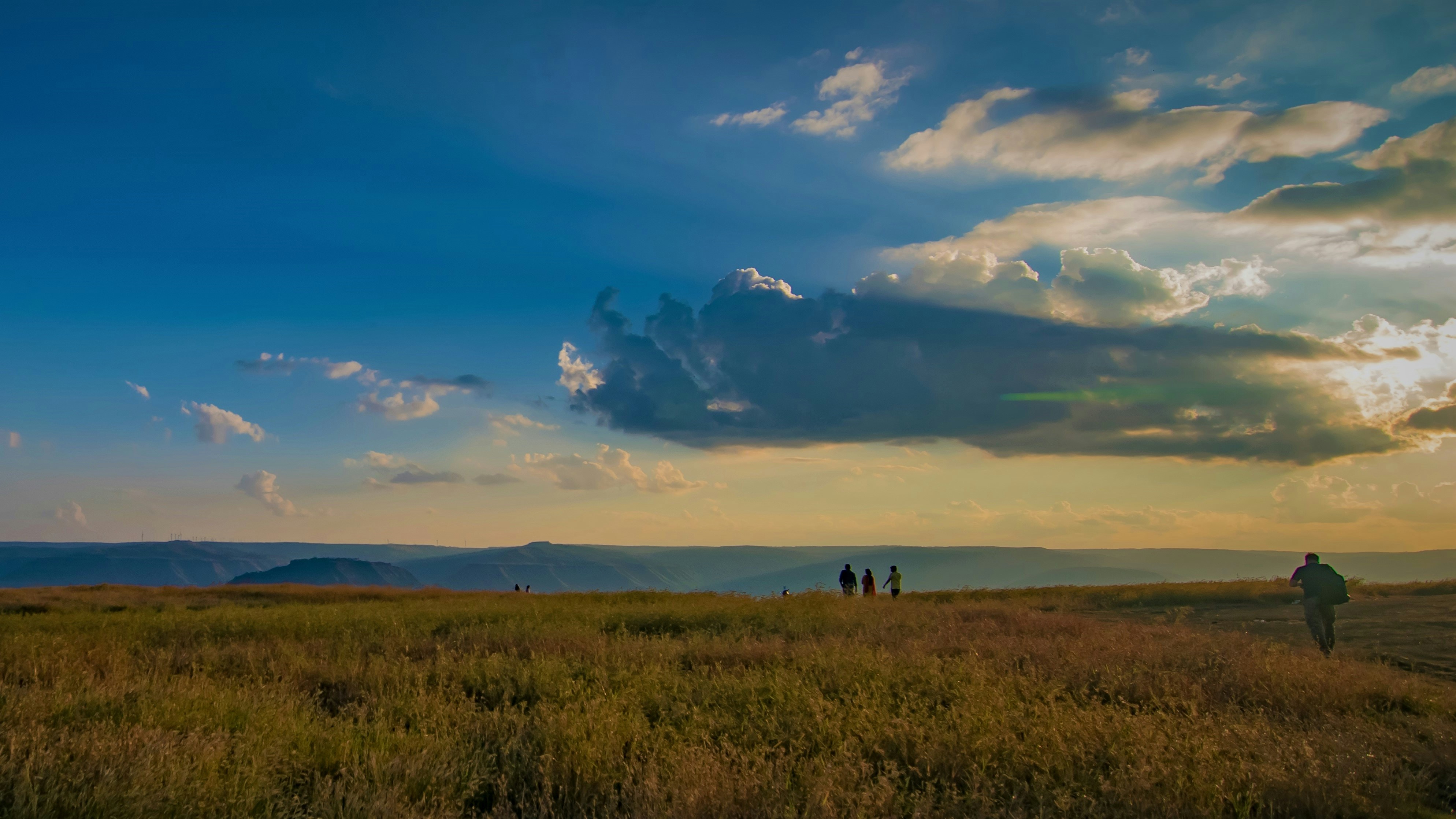 um grupo de pessoas em pé no topo de um campo verde exuberante