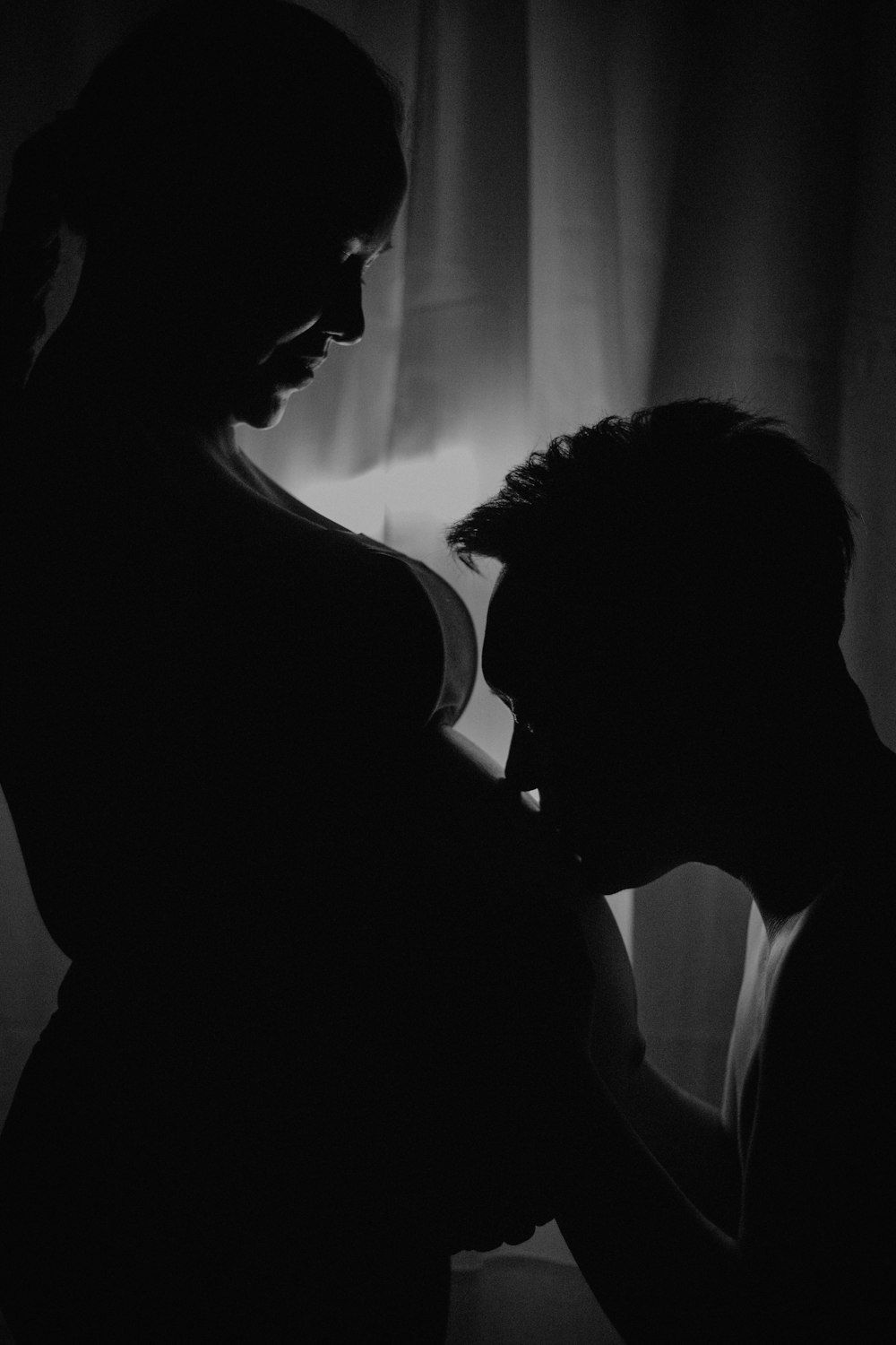 a man standing next to a woman in a dark room