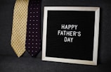 a father's day sign next to two ties