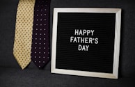 a father's day sign next to two ties