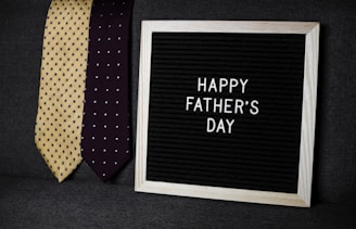 a father's day sign next to two ties