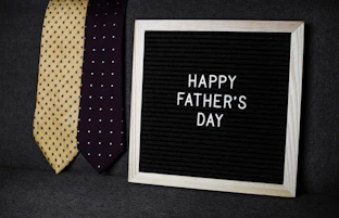 a father's day sign next to two ties