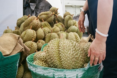 a person standing next to a pile of fruit