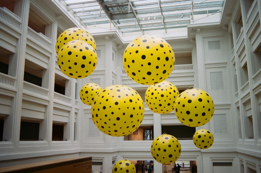 a group of yellow and black polka dots hanging from a ceiling