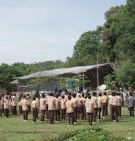An outdoor coaching session in Durgapur with students eagerly taking notes under the shade of trees.