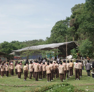 An outdoor coaching session in Durgapur with students eagerly taking notes under the shade of trees.