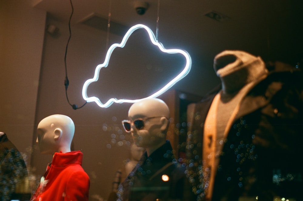 a group of mannequins are standing in front of a window