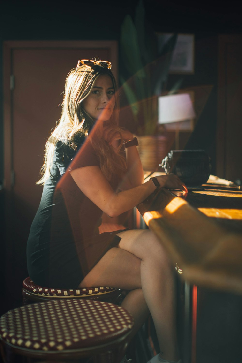 a woman sitting at a bar with a camera