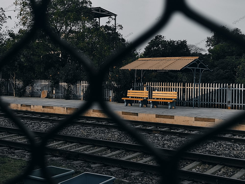 a yellow bench sitting on the side of a train track