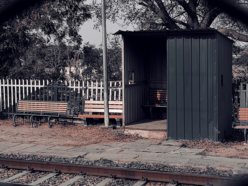 a couple of benches sitting next to a train track