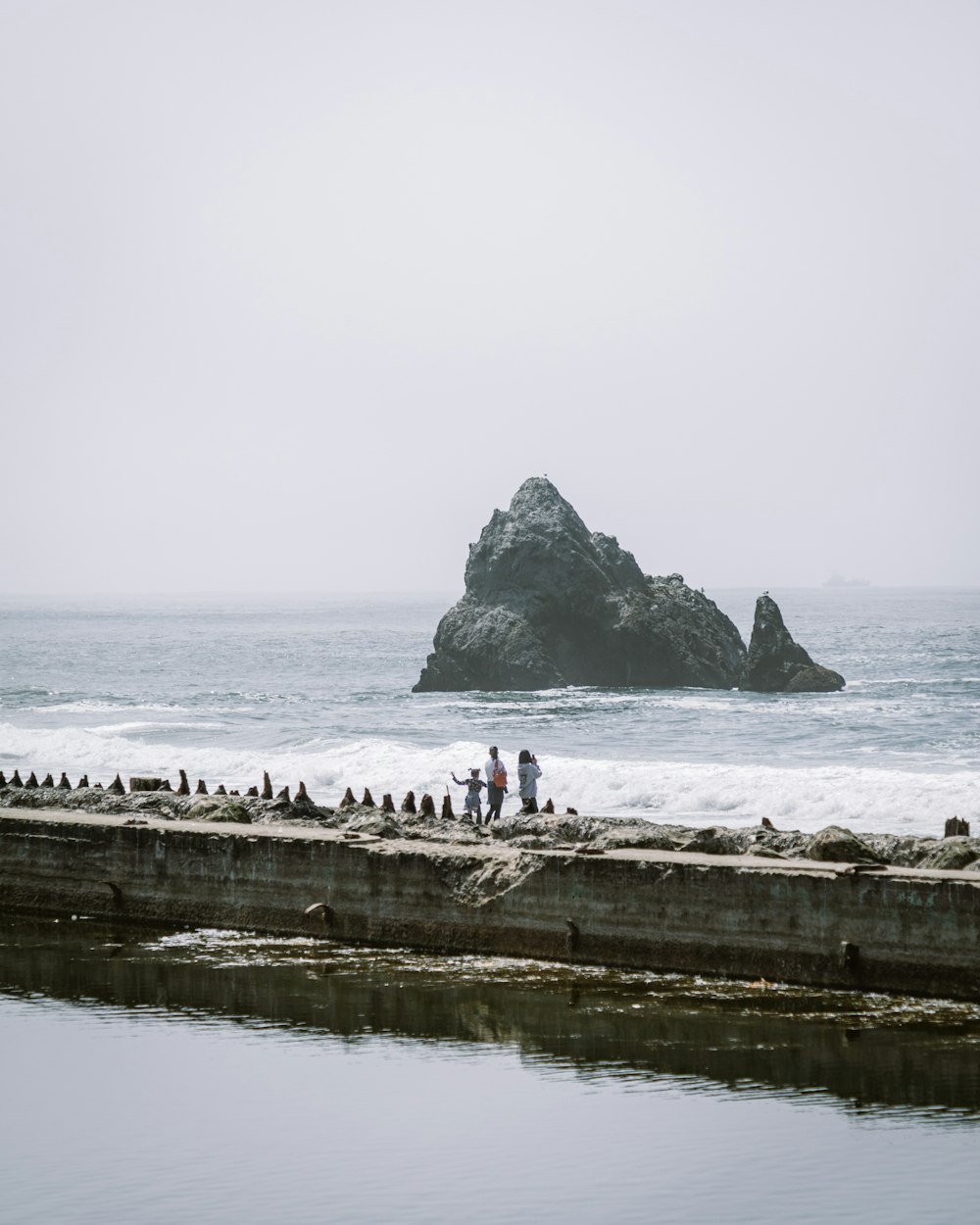 a group of people standing next to a body of water