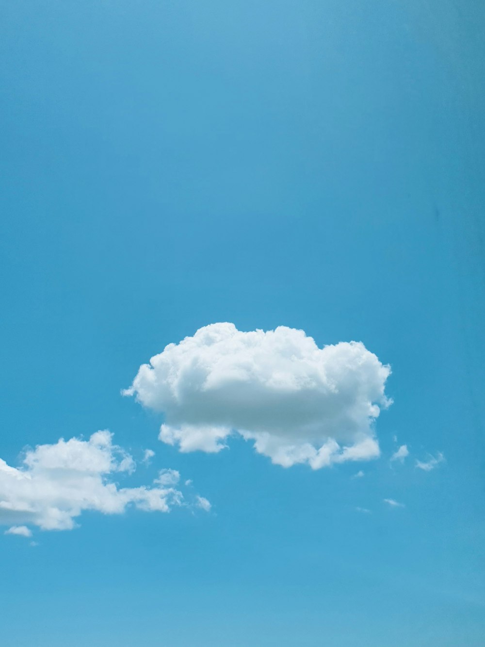 a lone cloud in a blue sky