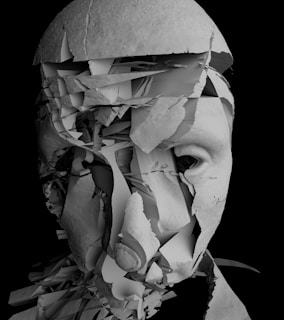 a black and white photo of a man's face covered in torn paper