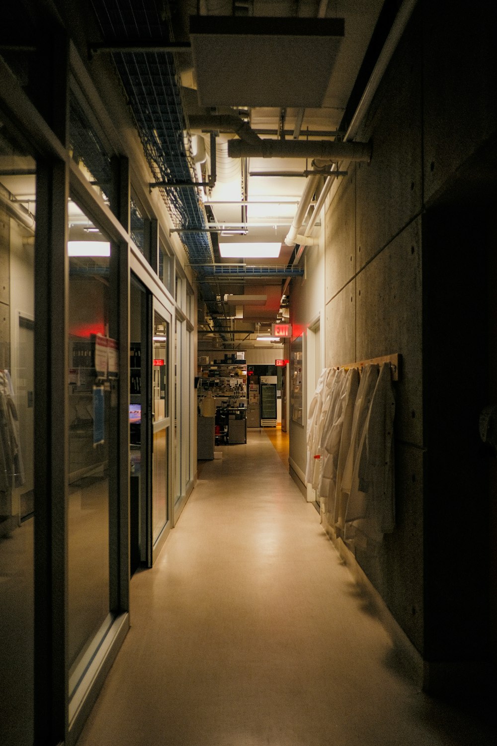 a long hallway with glass doors leading to another room