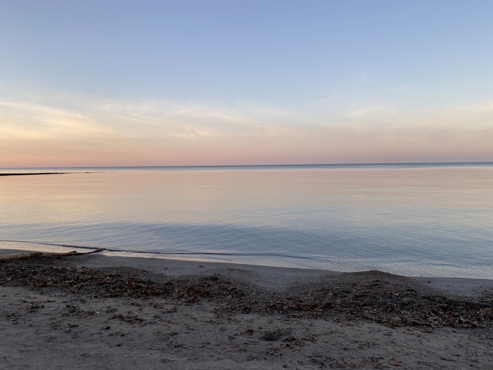 a body of water sitting next to a sandy beach