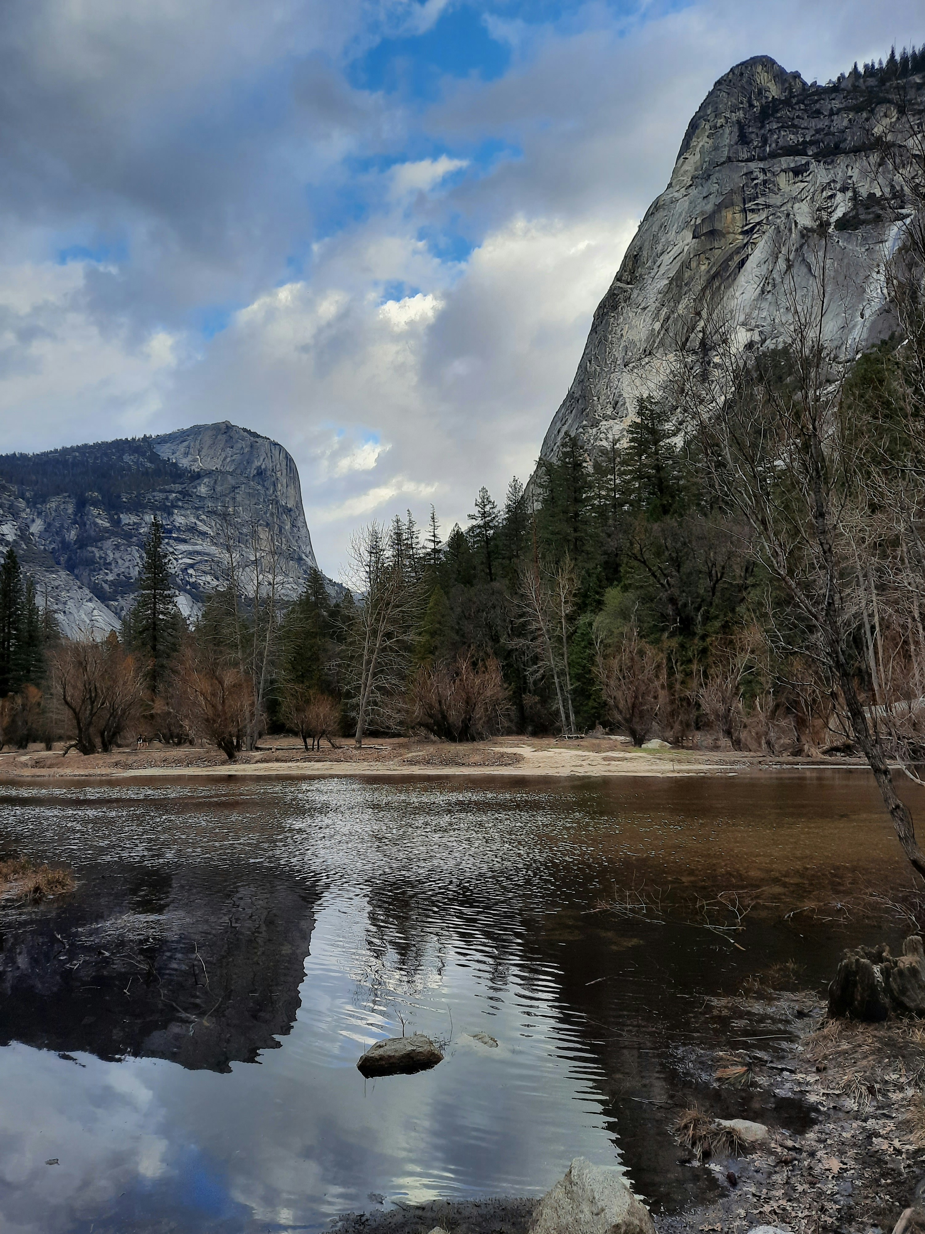 un plan d’eau entouré de montagnes et d’arbres