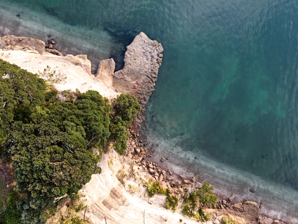 an aerial view of a beach with a rock outcropping