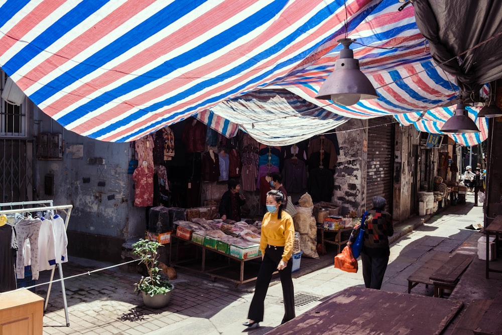 a woman wearing a face mask walking down a street