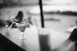 High-contrast image of a classic cocktail being stirred in a crystal mixing glass, with deep green and gold accents.