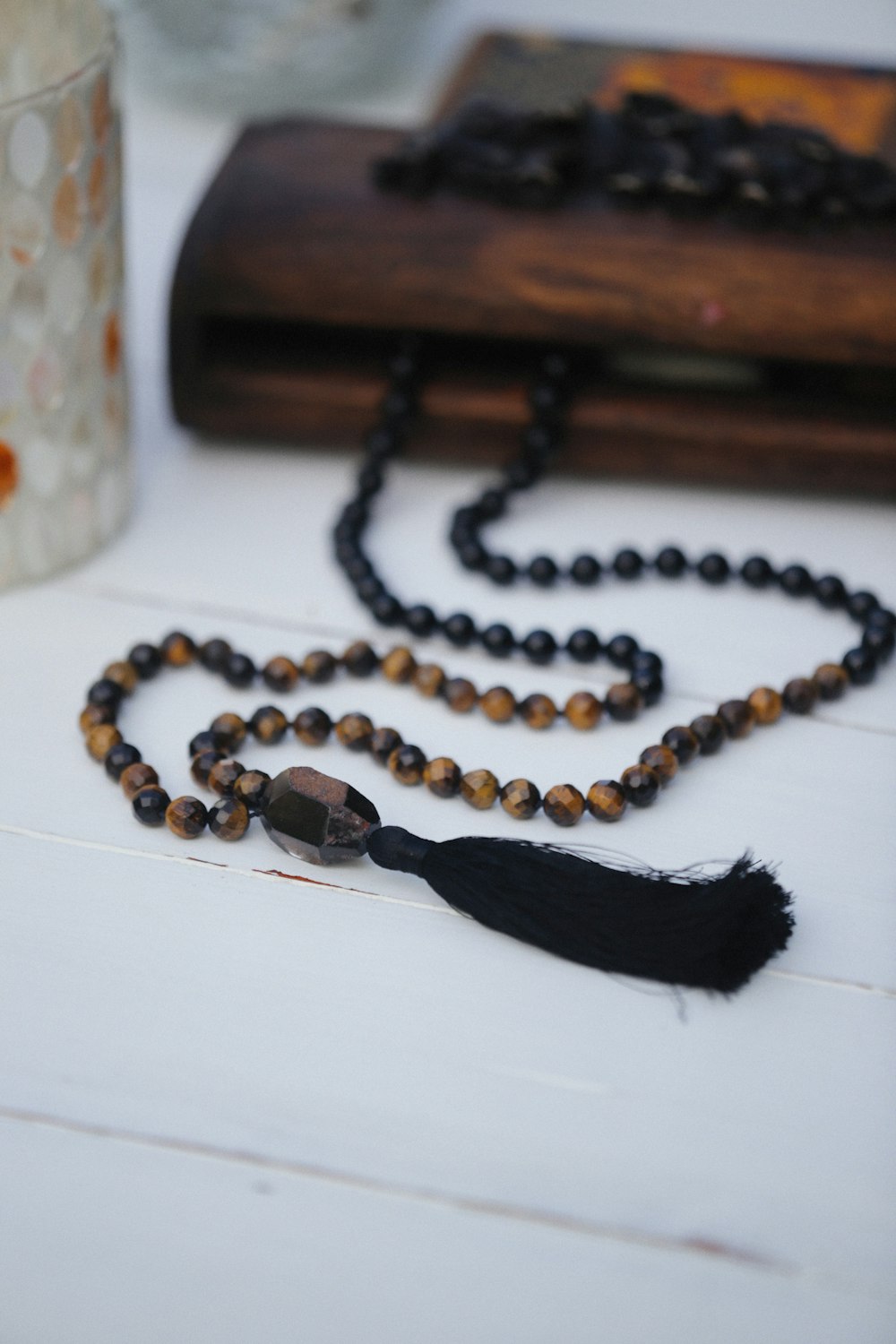 a beaded necklace with a tassel on a table