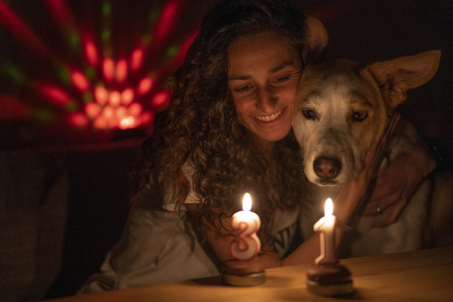 Woman and dog with candles and disco light
