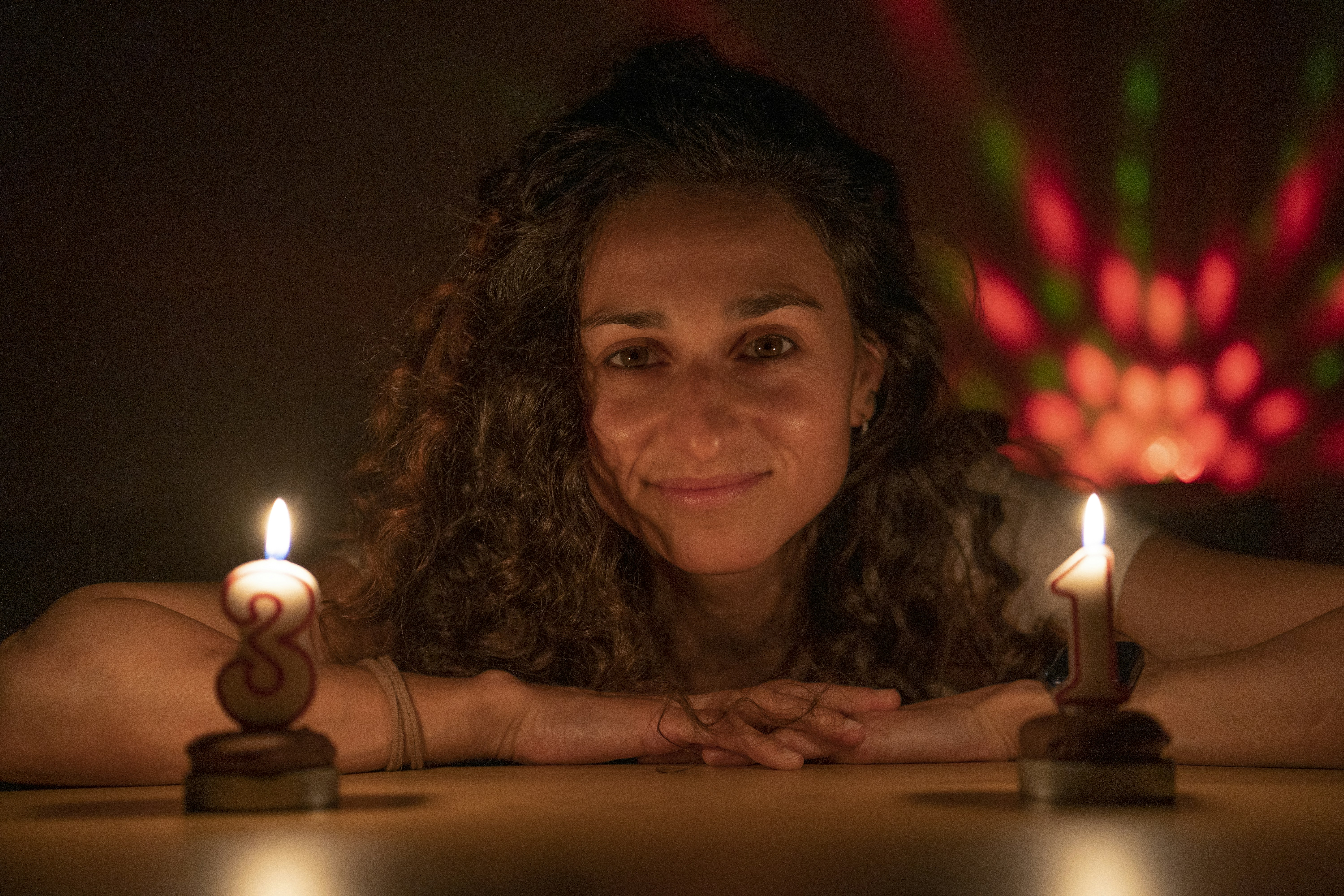 Woman with curly hair and two candles