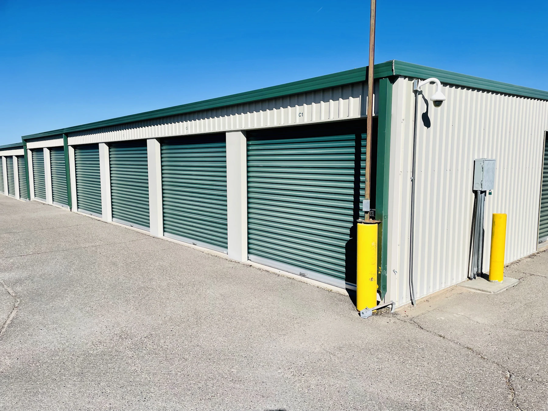 Row of self-storage units with roll-up doors at a sunlit Arizona storage facility
