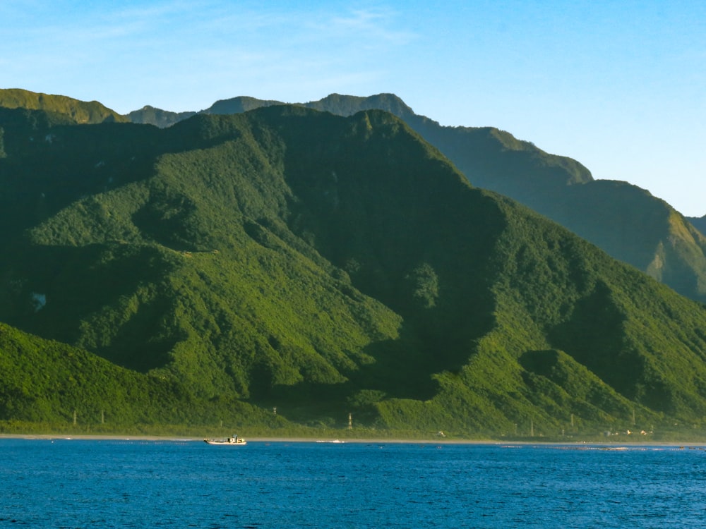 a boat on a body of water near a mountain range