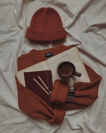 A cozy setup featuring knitwear and accessories on a table.