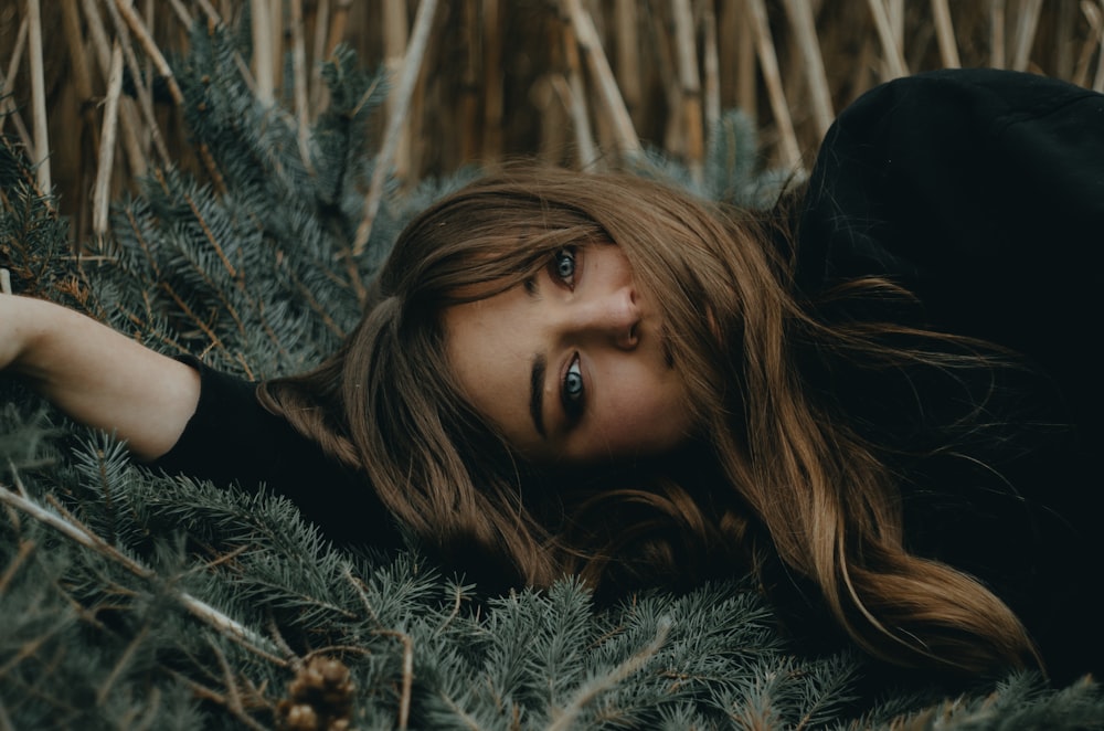 a woman laying in the grass with her eyes closed