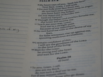 A close-up of an open hymnal displaying handwritten Christian song lyrics and musical notes.