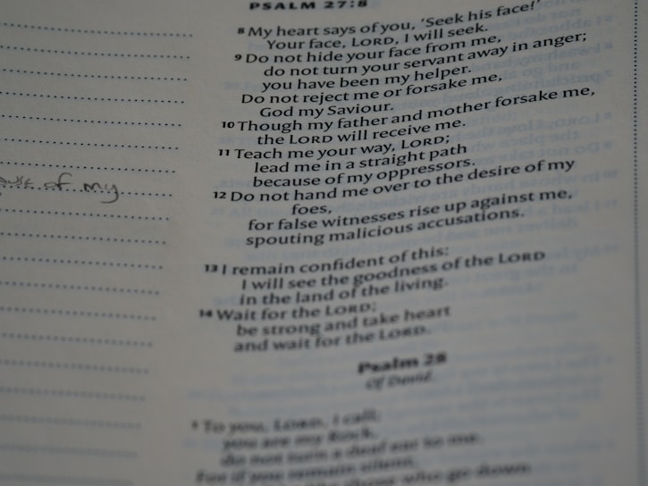 A close-up of an open hymnal displaying handwritten Christian song lyrics and musical notes.