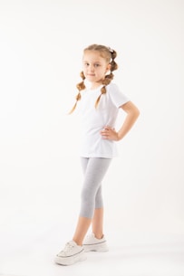 a little girl is standing with her hands on her hips