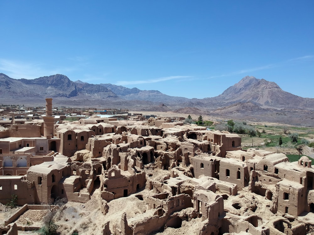 a village in the middle of a desert with mountains in the background