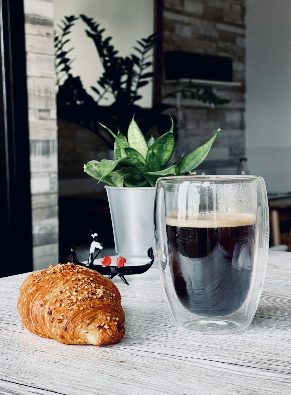 a croissant and a cup of coffee on a table