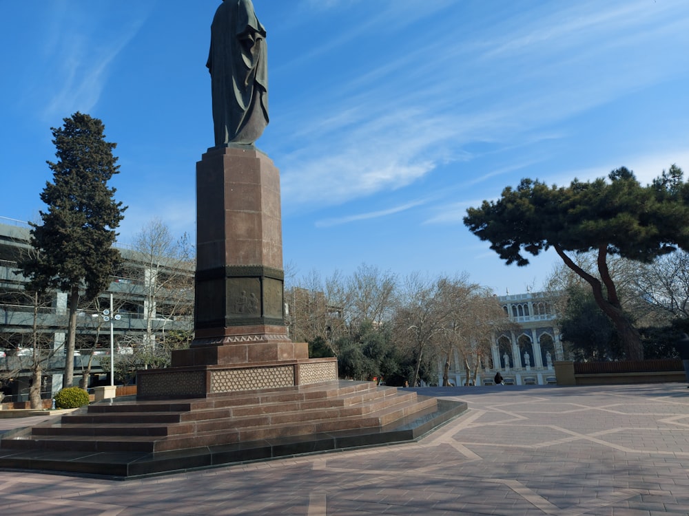 a statue of a man holding a cross in a plaza