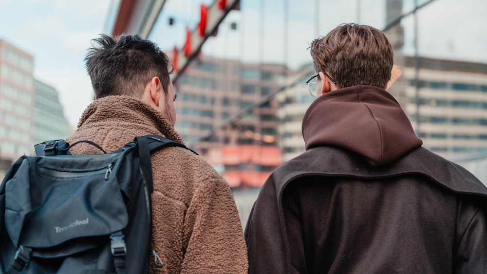 a couple of men walking across a bridge