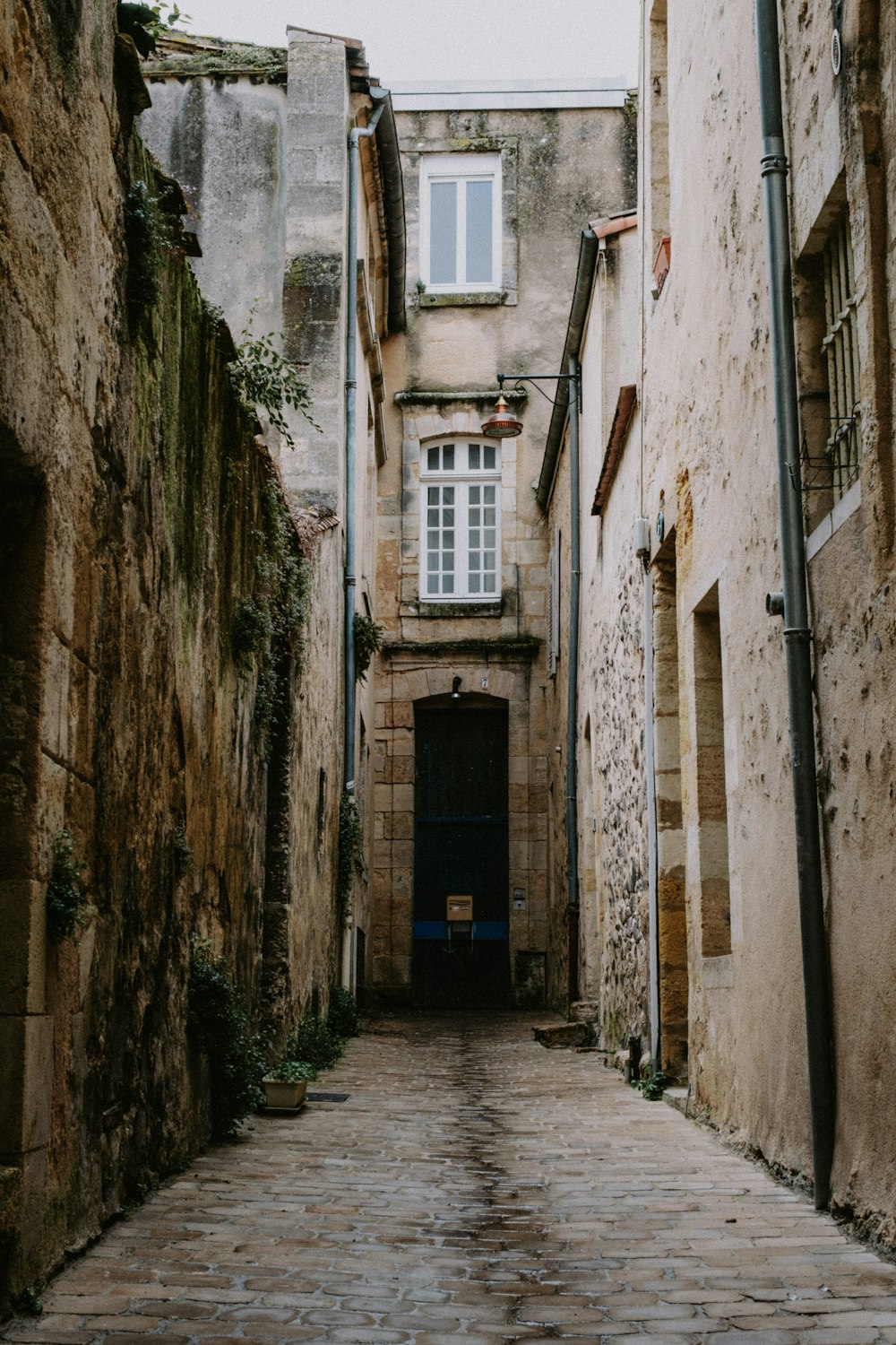 a narrow alley way with a blue door