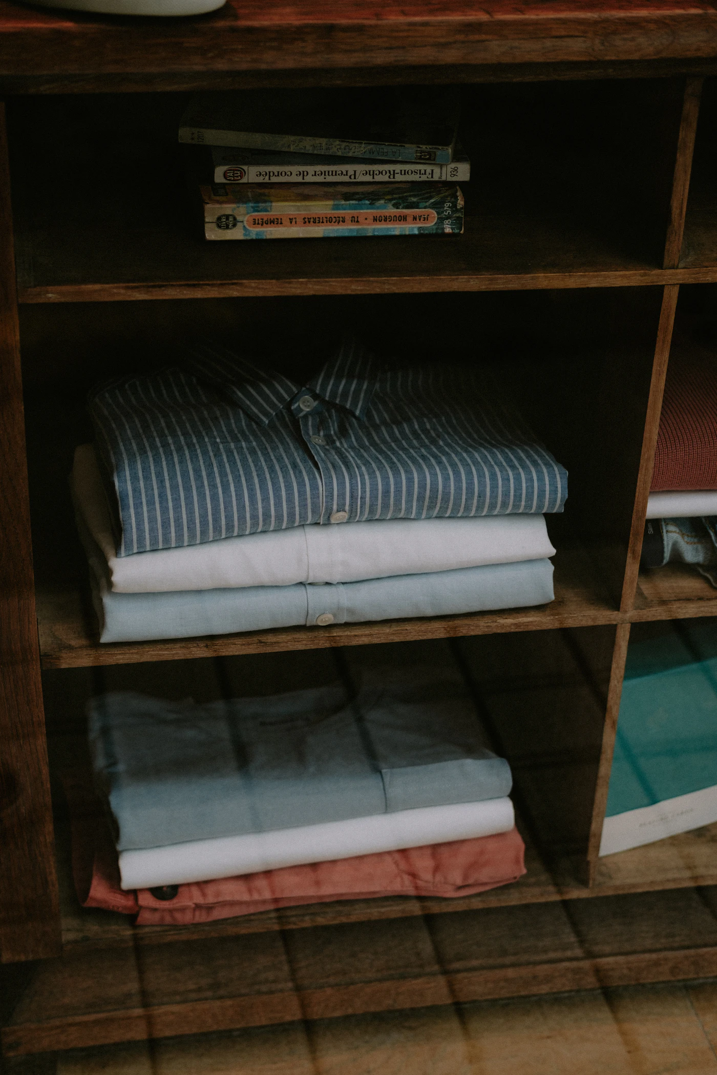 Folded linen stacked on a storeroom shelf