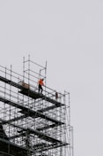 a man standing on a scaffold on top of a building