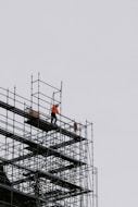 a man standing on a scaffold on top of a building