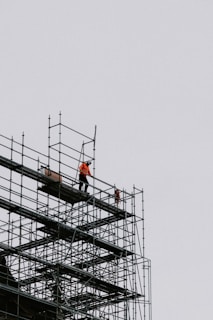a man standing on a scaffold on top of a building