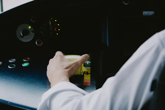 Close-up of a hand operating a metallic control panel illuminated with blue LED lights.