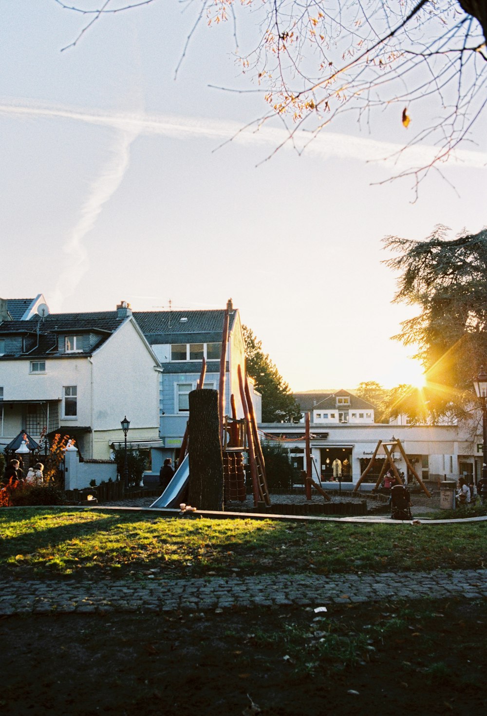 a playground in front of a large white house