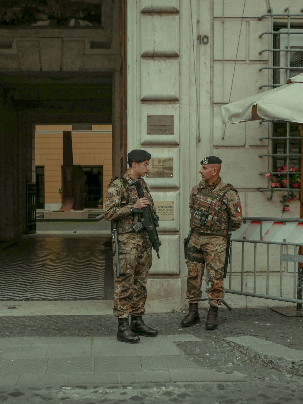 two soldiers standing next to each other in front of a building