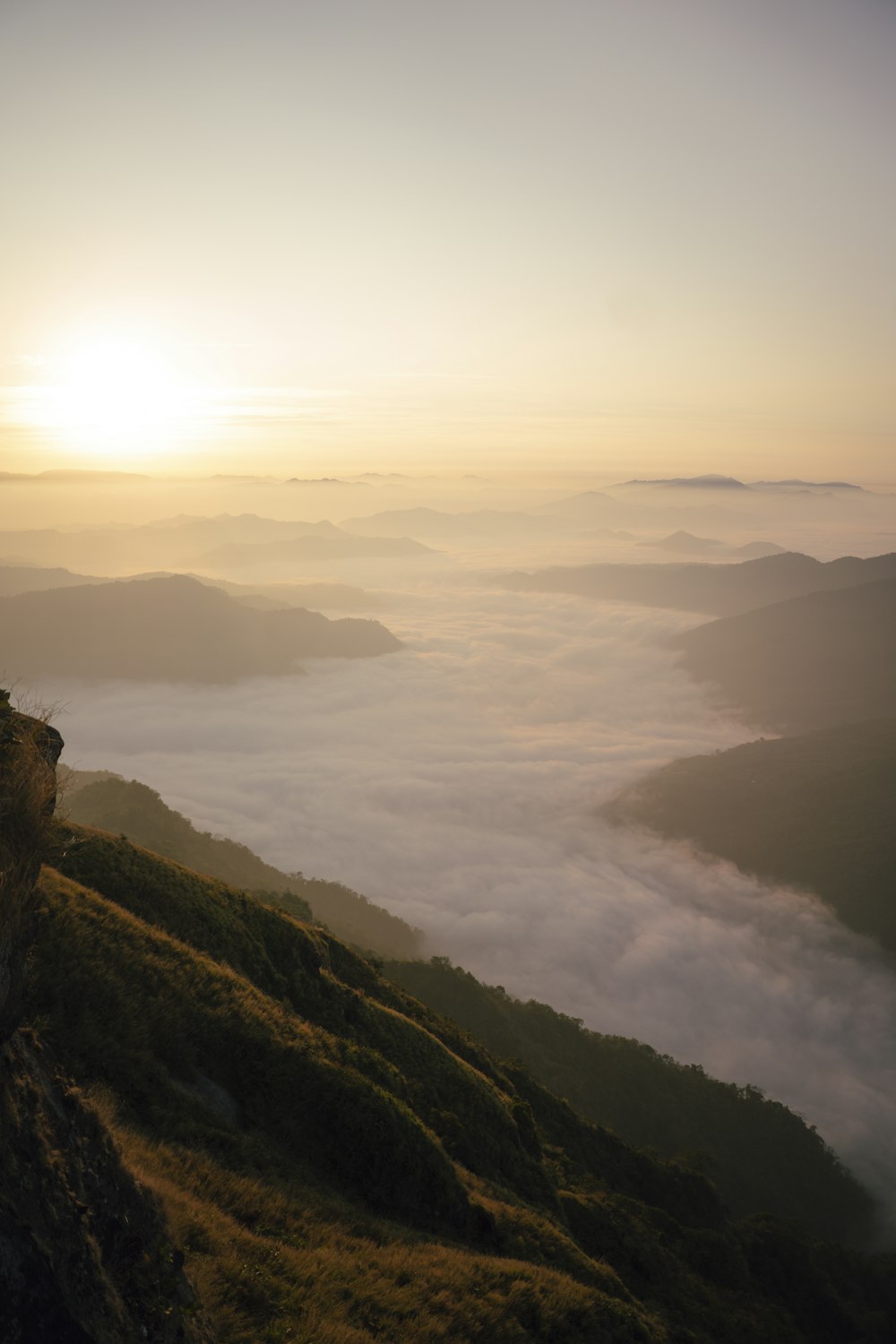 a person standing on top of a mountain overlooking a foggy valley