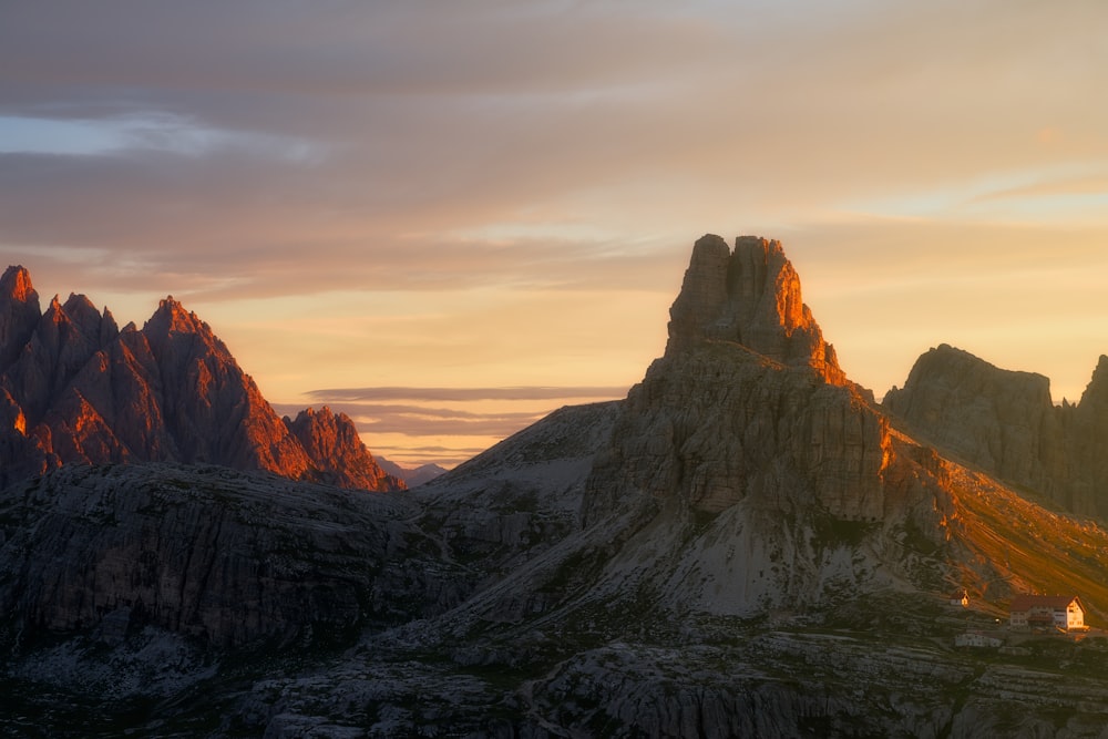 Una cadena montañosa con una puesta de sol al fondo